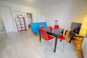 una sala da pranzo con tavolo nero e sedie rosse di HITrental Stauffacher Apartments a Zurigo