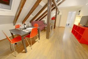 una sala da pranzo con tavolo e sedie arancioni di HITrental Oerlikon Apartments a Zurigo