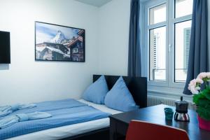 1 dormitorio con cama, escritorio y ventana en HITrental Old Town Apartments, en Lucerna