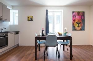 eine Küche mit einem Esstisch und Stühlen in der Unterkunft HITrental Altstetten Apartments in Zürich