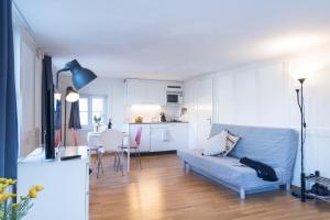 a living room with a blue couch and a kitchen at HITrental Zeughausgasse - Apartment in Zug