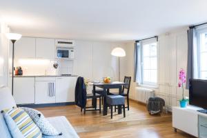 a living room with a kitchen and a dining room table at HITrental Zeughausgasse - Apartment in Zug