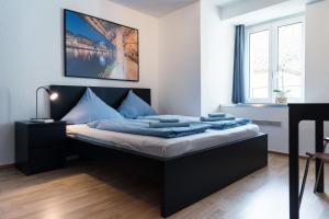 a bedroom with a bed with blue sheets at HITrental Old Town Apartments in Lucerne