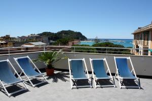 Hotel Genova في سيستري ليفانتي: مجموعة من الكراسي الزرقاء على السطح