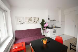 チューリッヒにあるハイトレンタル シュタウファッハー アパートメンツの紫色のソファとテーブル付きのリビングルーム