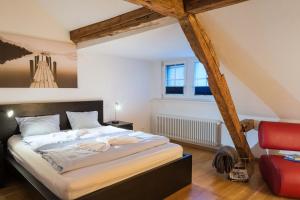1 dormitorio con 1 cama grande y 1 silla roja en HITrental Zeughausgasse - Apartment en Zug