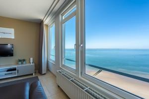 una camera con una grande finestra con vista sull'oceano di Strandappartementen De Gulden Stroom a Vlissingen