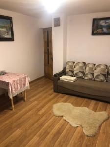 een woonkamer met een bank en een tafel bij Садиба "Сонячна" in Kosiv