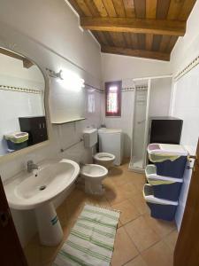 een badkamer met een wastafel en 2 toiletten bij B&B Le Stagioni in Castel del Monte