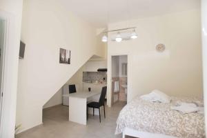 ein Schlafzimmer mit einem Bett und einem Tisch sowie eine Küche in der Unterkunft Isola bella in Isola delle Femmine