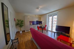 a living room with a red couch and a kitchen at HITrental Oerlikon Apartments in Zürich