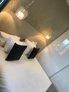 a bed with black and white pillows in a room at Appartements de Standing - Panate in Corte