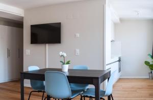 a dining room with a black table and blue chairs at HITrental Marktplatz Apartments in Basel