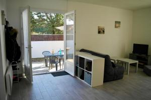 a living room with a sliding glass door to a patio at Charmante maison à 500 m de la côte, pour 4 in Notre-Dame-de-Monts