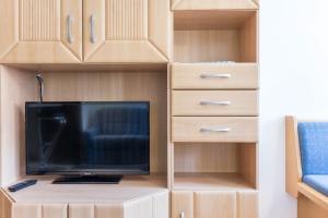 a tv sitting on top of a wooden cabinet at Apartments Christa App B2 in Ortisei