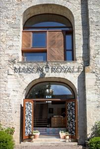 una entrada a un edificio con una señal sobre la puerta en La Maison Royale en Pesmes