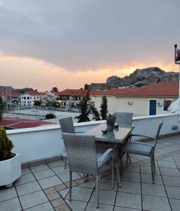 a patio with a table and chairs on a roof at D&K Studio in Myrina