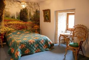 ein Schlafzimmer mit einem Bett, einem Tisch und einem Stuhl in der Unterkunft La Maison Royale in Pesmes