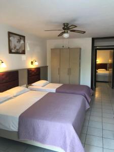 a bedroom with two beds and a ceiling fan at AZALEA HOTEL in Sarti