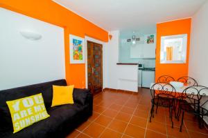 a living room with a black couch and orange walls at Pé na Praia by OCvillas in Albufeira