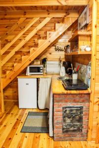 a kitchen in a wooden cabin with a stove at Na Soltyskiej in Mrągowo