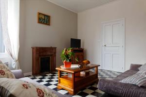 een woonkamer met een bank en een salontafel bij Le cachet d’une maison de centre-bourg à Beauvoir-sur-Mer in Beauvoir-sur-Mer