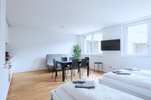 - un salon avec une table et une salle à manger dans l'établissement HITrental Messe Apartments, à Bâle