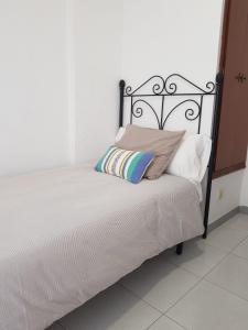 ein Bett mit einem schwarzen Rahmen und einem Kissen darauf in der Unterkunft Apartamento Antonio Machado in Barbate