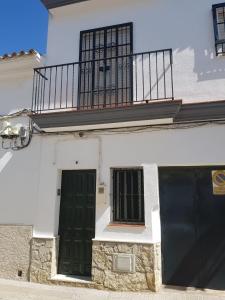 ein weißes Gebäude mit zwei Türen und einem Balkon in der Unterkunft Apartamento Antonio Machado in Barbate