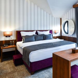 a bedroom with a large bed and a table at Heritage Hotel Krone in Sarajevo +66 photos