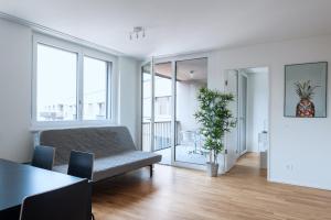 a living room with a couch and a table at HITrental Messe Apartments in Basel +78 photos