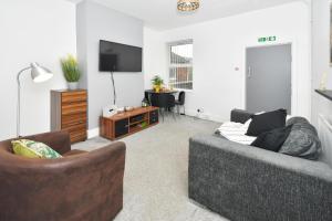 a living room with a couch and a tv at Boothen House by YourStays in Stoke on Trent