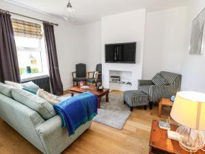 a living room with a couch and a tv at Sunnyside Villa in Holmfirth