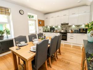 a kitchen and dining room with a wooden table and chairs at Sunnyside Villa in Holmfirth