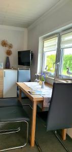 a dining room table with two chairs and a television at Ferienhaus Sonneck in Klockenhagen