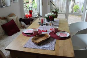 a wooden table with red plates and cups on it at Bed & Breakfast Bodensee mit Herz in Stockach