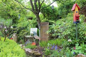 a garden with a bird house and a chair at Bed & Breakfast Bodensee mit Herz in Stockach
