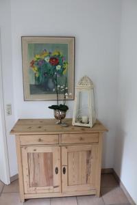 a wooden cabinet with a vase of flowers on it at Bed & Breakfast Bodensee mit Herz in Stockach