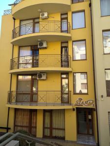 スヴェティ・ヴラスにあるSiana 2 Apartmentsの黄色の建物(バルコニー、窓付)