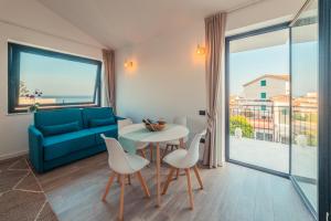 a living room with a blue couch and a table and chairs at Nacàri Home in Giardini Naxos