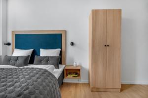 a bedroom with a large bed and a wooden cabinet at STUDIO1A Hotel Apartments in Copenhagen