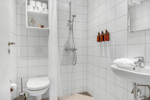 a bathroom with a shower and a toilet and a sink at STUDIO1A Hotel Apartments in Copenhagen