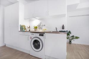 a white kitchen with a washing machine and a sink at STUDIO1A Hotel Apartments in Copenhagen
