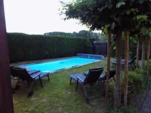 una piscina con 2 sillas y una mesa al lado en Villa Maas & Kempen, en Maaseik