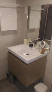 Un baño con un lavabo blanco y un espejo. en Studio centre Carroz CA210, en Les Carroz d'Araches