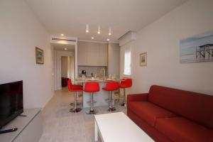 a living room with a red couch and red chairs at Casa Plauto con appartamento grande in Bellaria-Igea Marina