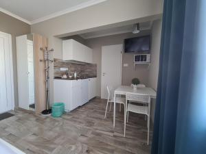 a kitchen and dining room with a table and chairs at Surman Apartmanok in Siófok