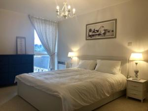 a bedroom with a bed with a chandelier and a window at Toothbrush Apartments - Ipswich Waterfront - Anchor St in Ipswich