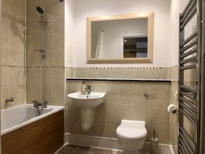a bathroom with a sink and a toilet and a mirror at Toothbrush Apartments - Ipswich Waterfront - Anchor St in Ipswich +16 photos