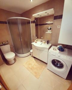 a bathroom with a shower and a washing machine at Beauty apartment in Blue star complex Pržno Montenegro in Pržno